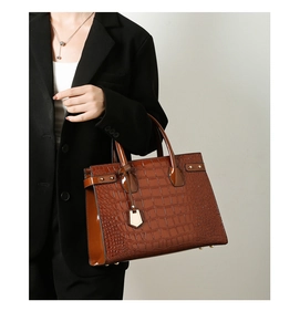 Caramel brown crocodile embossed leather tote bag with gold hardware shown on model