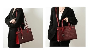 Detail view of large burgundy crocodile pattern handbag with side strap and handles