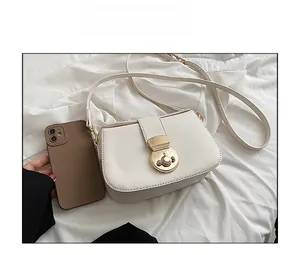 Size comparison of white minimalist leather crossbody bag with round gold metal buckle