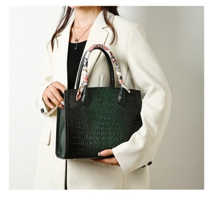 Bolso de mano verde oscuro con relieve de cocodrilo y pañuelo de seda en el asa