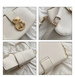 Detail view of white leather shoulder bag with gold metal buckle and adjustable strap