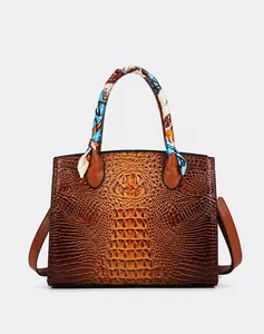 Detalle del bolso tote marrón con textura de cocodrilo y un pañuelo de seda decorativo