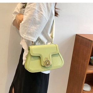 Close-up of mint green faux leather crossbody bag with vintage gold crown compass buckle