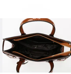 Detail view of the brown crocodile pattern handbag interior with secure zipper pockets