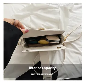 Top view of the spacious interior of a white leather crossbody bag with daily essentials