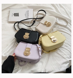 Flat lay of multiple minimalist leather crossbody bags in four soft colors with gold buckles