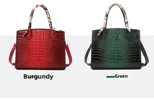 Detalle de bolsos burdeos y verdes con textura de cocodrilo y asas con pañuelo