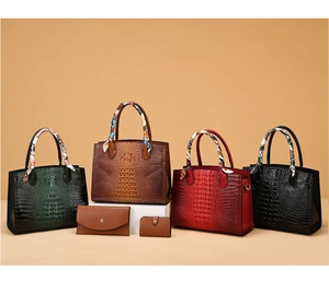 Detalle de cuatro bolsos con estampado de cocodrilo en verde, marrón, rojo, negro y pañuelos