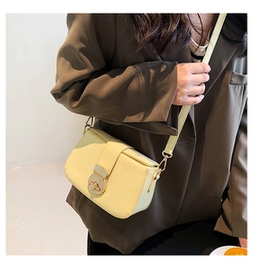 Detailed view of cream PU leather crossbody bag featuring a round gold metallic buckle