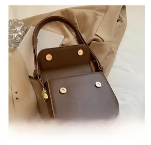 Detailed view of brown PU leather shoulder bag featuring four secure golden magnetic snaps