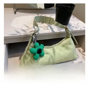 Light green woven shoulder bag with floral charm and acrylic chain detail