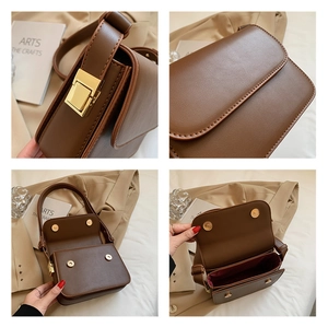 Detail showing the dark brown square crossbody bag with gold metal clasp and interior lining