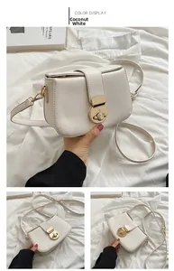 Detail of minimalist coconut white shoulder bag featuring a golden circular twist lock