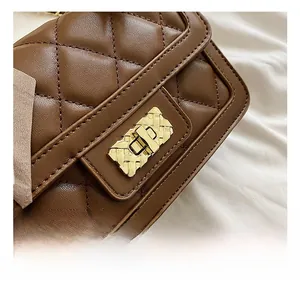 Macro detail of brown quilted leather bag featuring a gold metal twist lock fastener