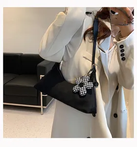 Minimalist black crescent shoulder bag with a black and white checkered flower charm