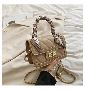 Close-up of khaki quilted leather crossbody bag with scarf-wrapped handle and metal lock