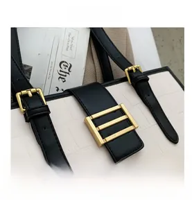 Detail showing white crocodile pattern leather with golden buckles and black straps