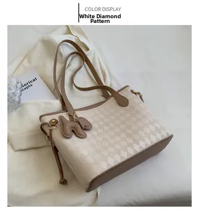 Detail of quilted white PU tote bag with dark brown dog charm in a lifestyle setting