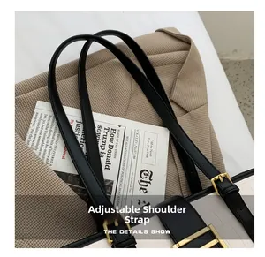 Detail of adjustable black leather shoulder strap on white crocodile pattern handbag