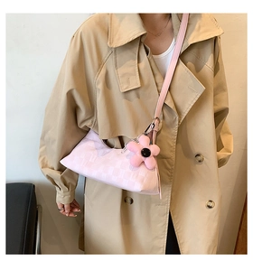 Detail of pink checkerboard shoulder bag with flower charm on khaki trench coat