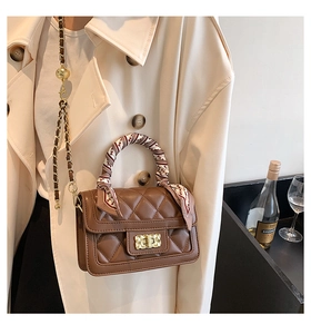 Close-up of brown quilted crossbody bag with silk scarf handle and gold hardware