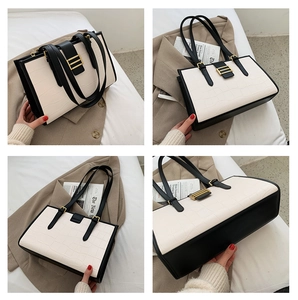 Detail view of cream crocodile pattern shoulder bag with black trim and gold hardware accents