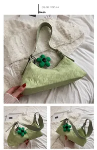 Close-up of light green plaid embossed shoulder bag with matching floral pendant charm