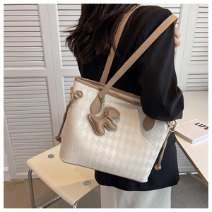 White quilted PU leather tote bag with brown straps and a dog charm shown on a model