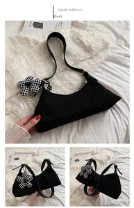 Detail of black semi-circle shoulder bag with woven texture and checkerboard flower charm