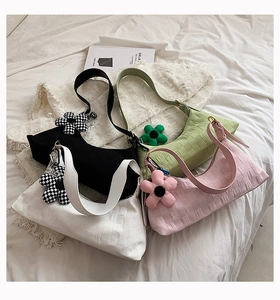 Detailed view of checkered shoulder bags in black, white, green, and pink with flower charms