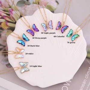 Close-up of colorful crystal butterfly pendants in various gradient hues with gold chain