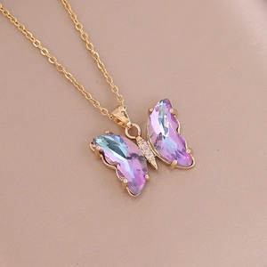 Close-up of purple gradient crystal butterfly pendant with gold chain and zircon accents