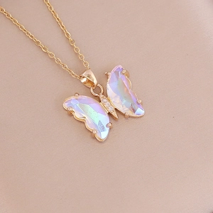 Close-up of golden butterfly pendant with iridescent resin wings on satin background