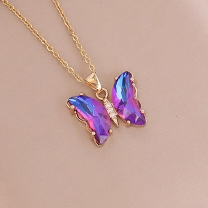 Macro detail of gold butterfly pendant with faceted purple and blue gradient crystals