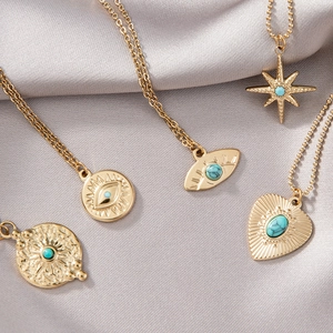 Detailset goldener Vintage-Halsketten mit Türkissteinen und geprägten Sonnenstrahl-Anhängern
