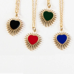 Dettaglio di ciondoli a cuore con smalto colorato e accenti di punte dorate lucide