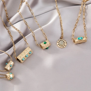Détails de pendentifs vintage œil protecteur et turquoise sur fond de soie