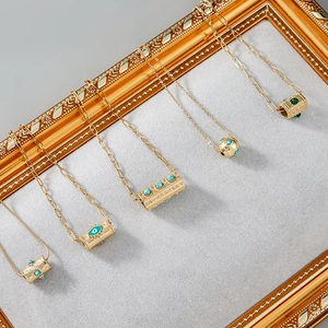 Détail de colliers vintage dorés avec pendentifs œil en turquoise et accents malachite