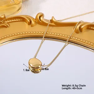 Vue détaillée du pendentif grain d'or avec mesures de taille et de poids sur miroir