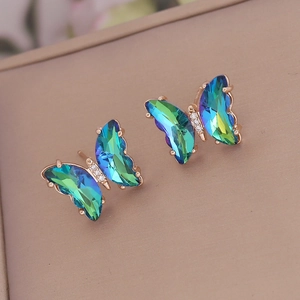 Detailed close-up of rose gold butterfly earrings with vibrant gradient crystal wings
