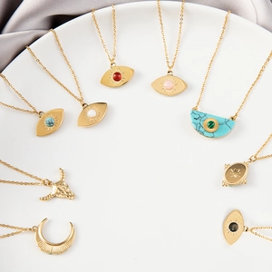 Bohemian gold plated star and evil eye necklaces with turquoise pendants on white plate