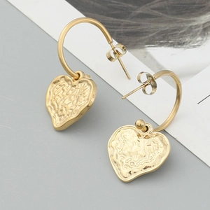 Elegant gold heart-shaped hoop earrings featuring a unique hammered metal texture finish
