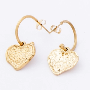 Detailed macro view of gold heart drop earrings with hammered vintage texture and C-hoops