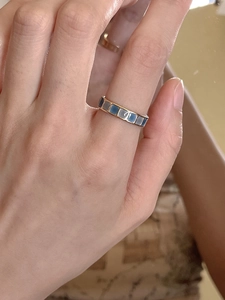 Detail of 18K gold ring featuring geometric square emerald and blue enamel inlay pattern