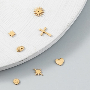 Détails macro de divers pendentifs dorés en acier titane avec formes de soleil et de cœur