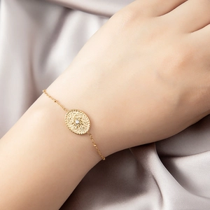 Bracelet élégant en acier doré 18K avec pendentif zircon soleil sur fond en satin doux
