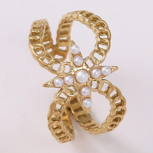 Macro detail of gold-plated starburst ring with white pearls and chain texture