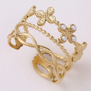 Detail of gold layered titanium steel ring with clover motif and white pearl inlay