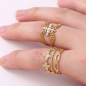 Layered gold titanium ring set with floral pearl accents and hollow bow design
