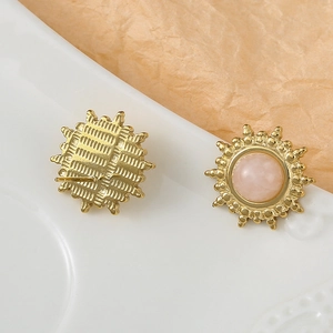 Détail de boucles d'oreilles tournesol dorées avec incrustation de pierre rose